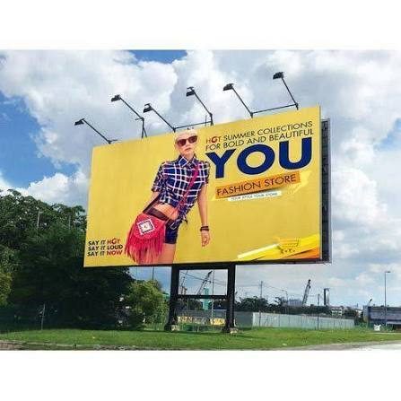 Yellow outdoor advertising billboard against a blue sky